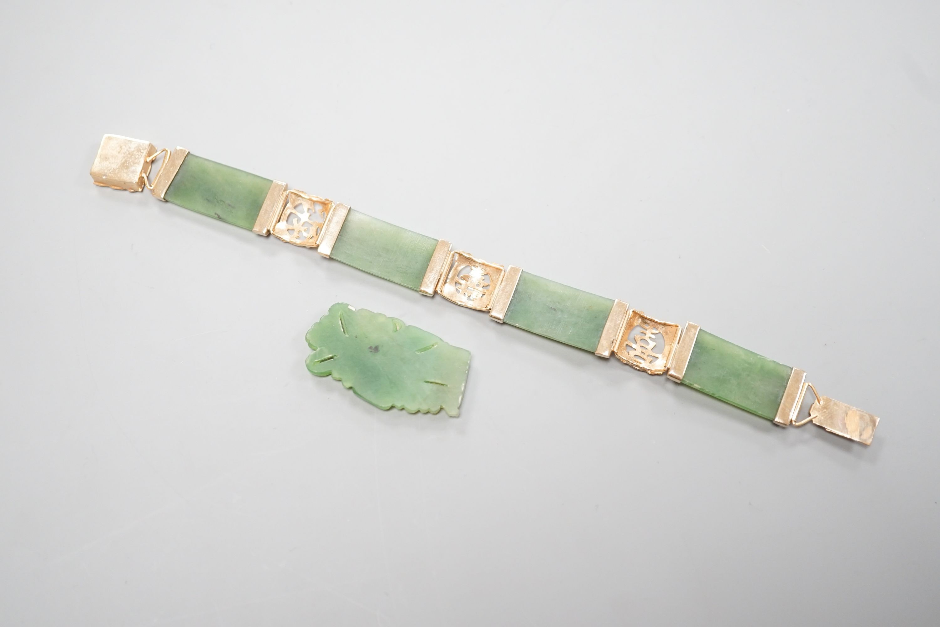 A gilt metal and jadeite mounted bracelet, 17.4cm and a carved plaque.